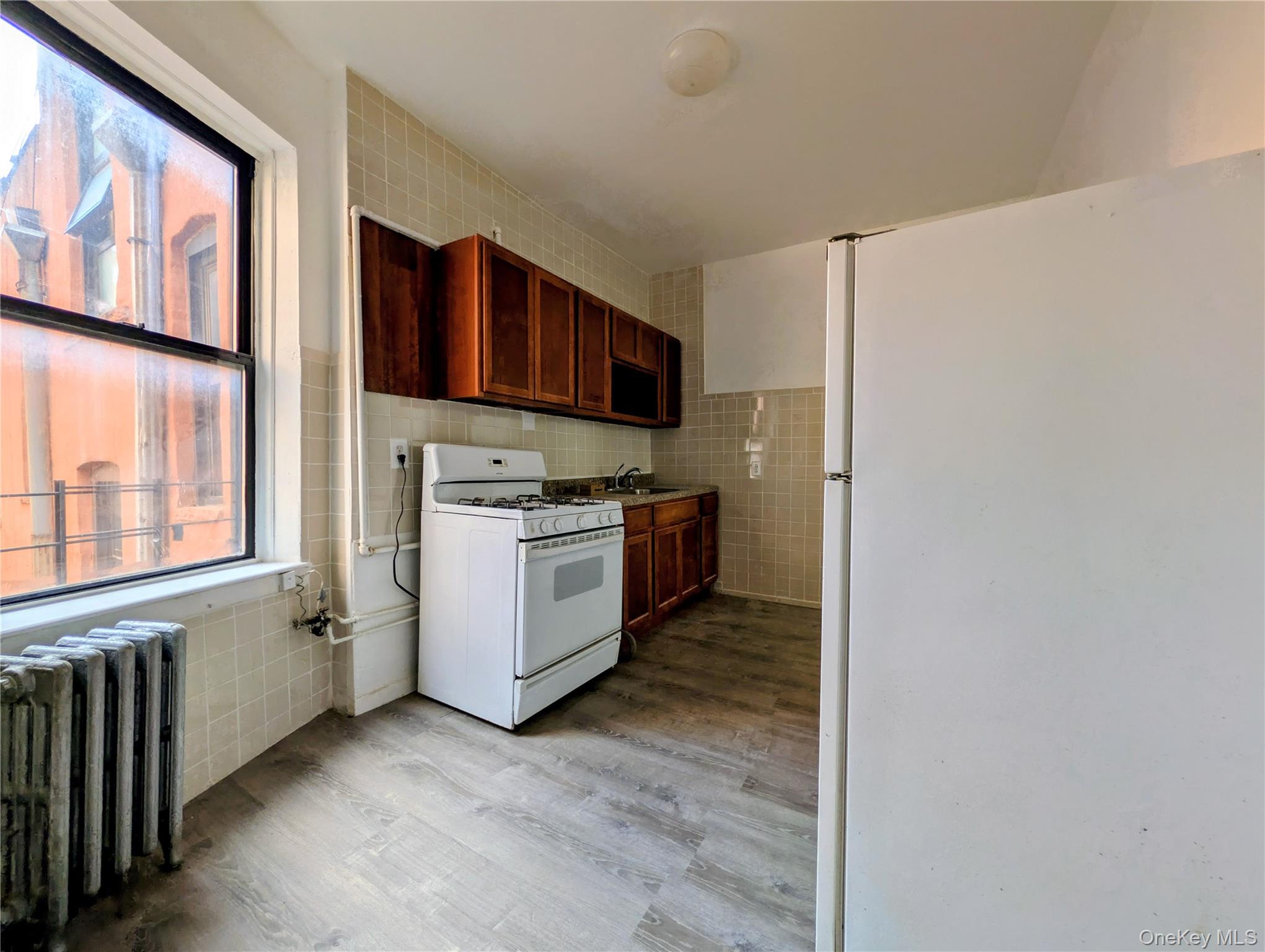 149 South 4th Street, Unit 25 Brooklyn, NY 11211 - Photo 3 of 12 a kitchen with stainless steel appliances a refrigerator and a stove top oven