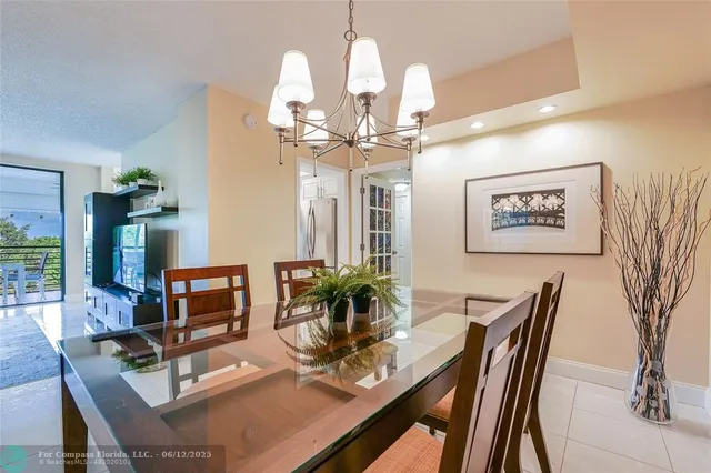 a large white kitchen with granite countertop a large window and stainless steel appliances