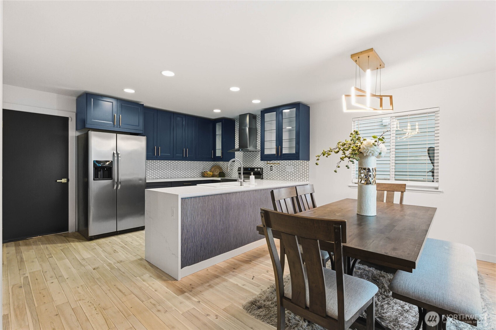 2513 Northeast 2nd Street Renton, WA 98056 - Photo 10 of 38 a kitchen with kitchen island a dining table chairs stainless steel appliances and cabinets