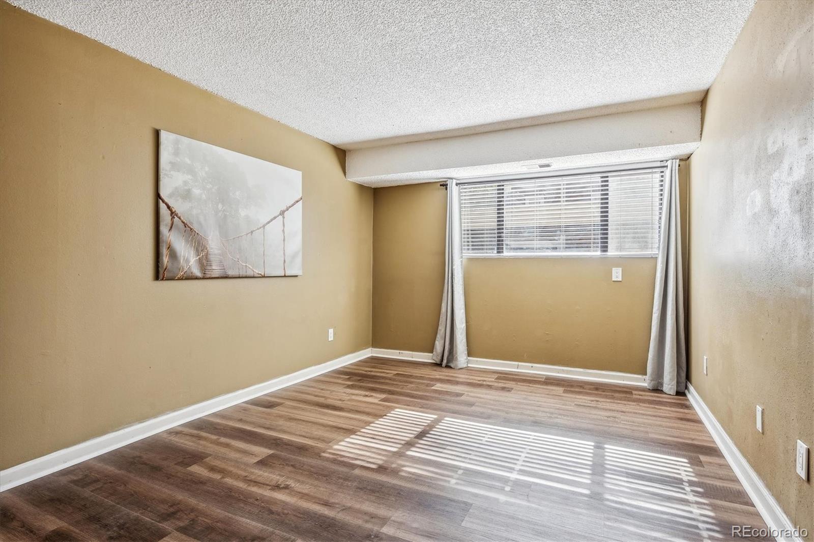 2141 Baseline Road, Unit 4 Boulder, CO 80302 - Photo 18 of 22 a view of an empty room with wooden floor and a window