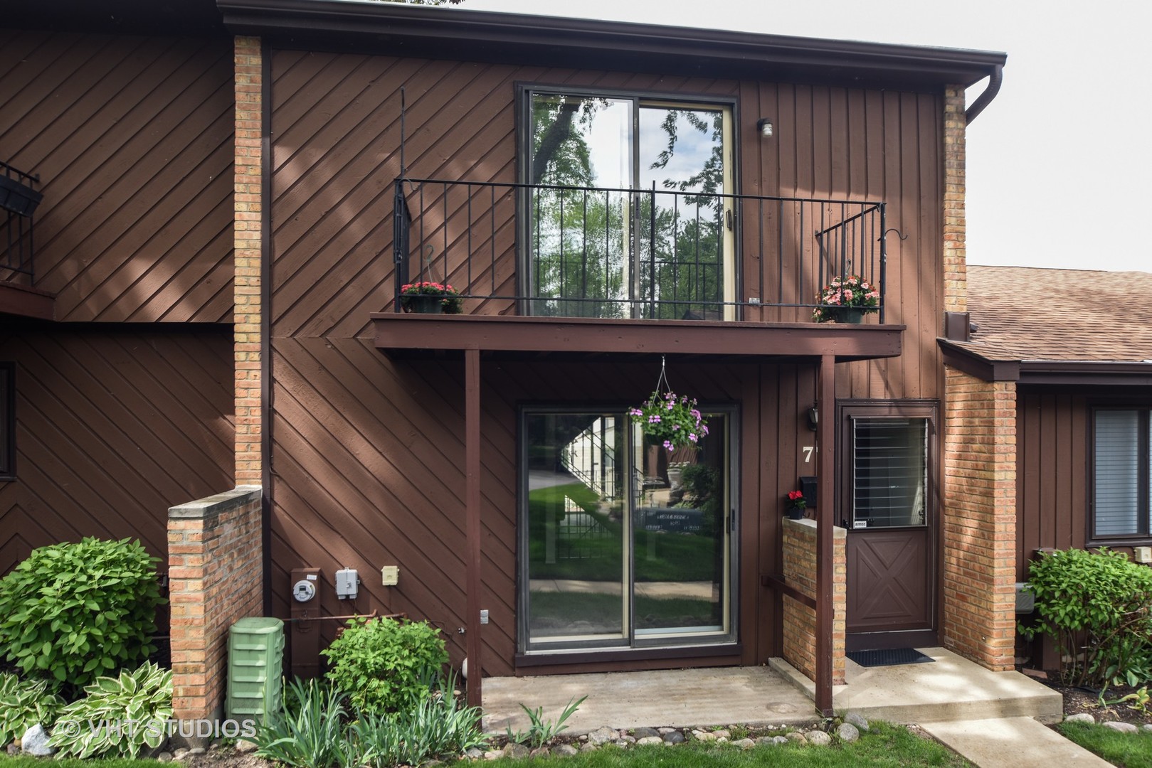 a view of a house with a large window and plants