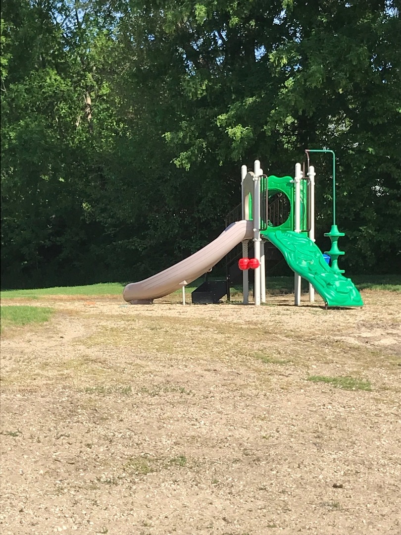 77 Mineola Road, Unit 77 Fox Lake, IL 60020 - Photo 18 of 24 a yellow and red umbrella sitting in the middle of a field