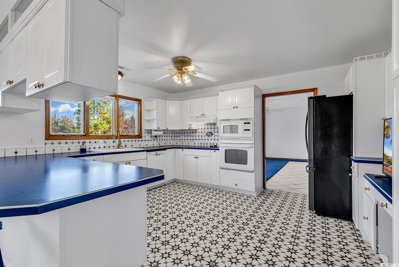 5938 Rahnavard Boulevard Myrtle Beach, SC 29588 - Photo 11 of 39 Kitchen with kitchen peninsula, white appliances,