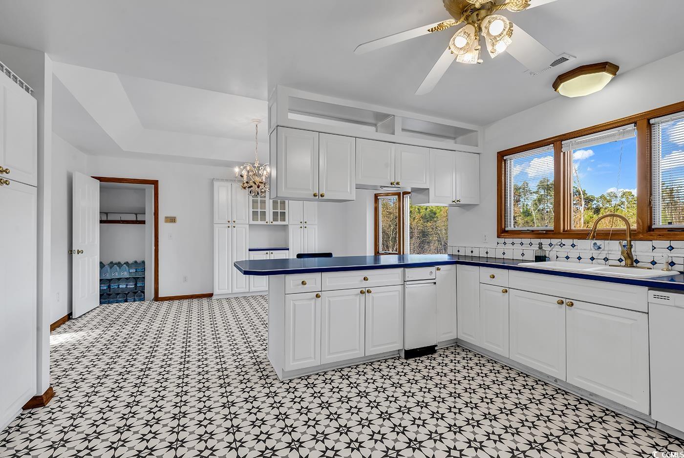 5938 Rahnavard Boulevard Myrtle Beach, SC 29588 - Photo 12 of 39 Kitchen featuring white cabinets, ceiling fan, dis