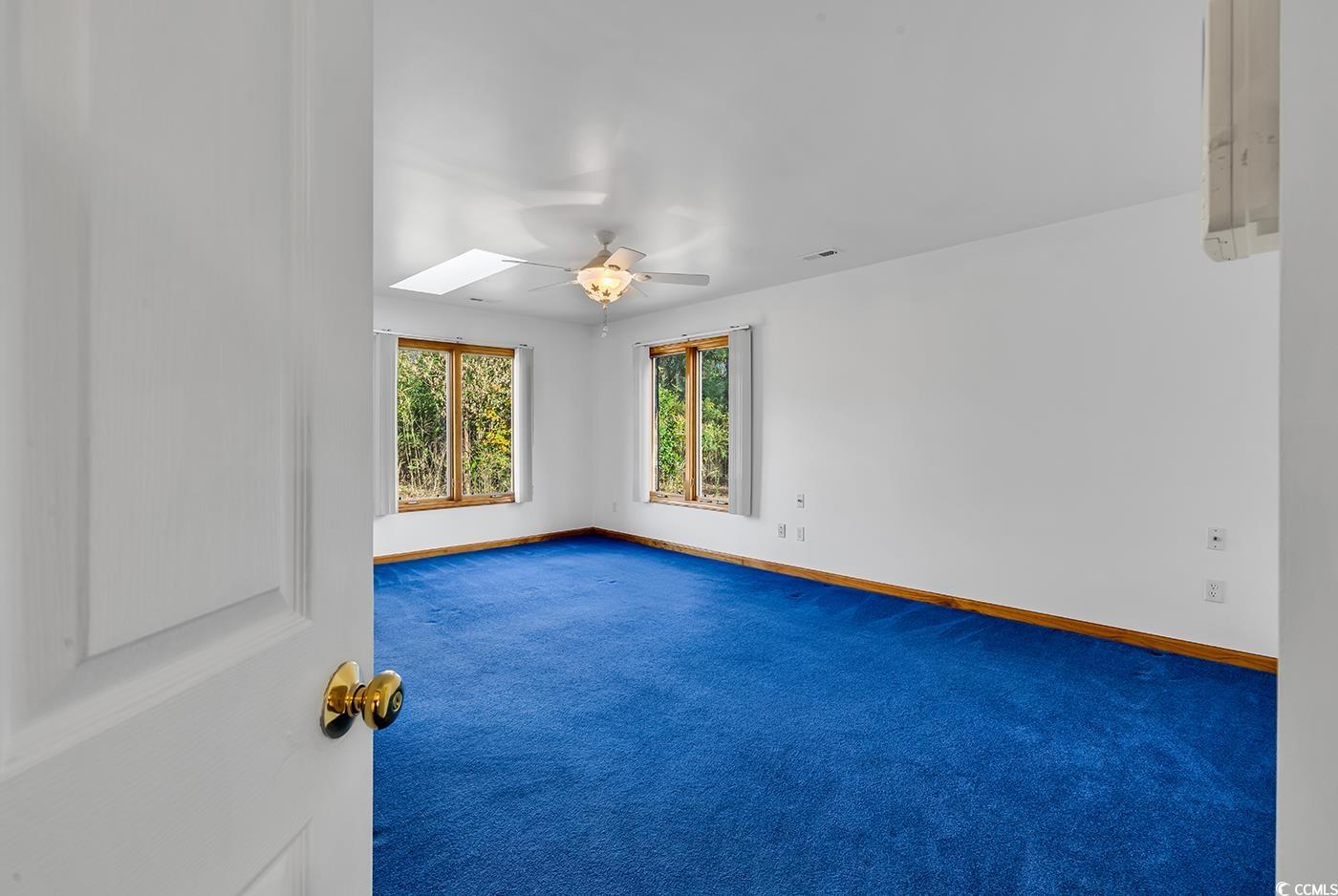 5938 Rahnavard Boulevard Myrtle Beach, SC 29588 - Photo 15 of 39 Carpeted spare room with ceiling fan and a skyligh