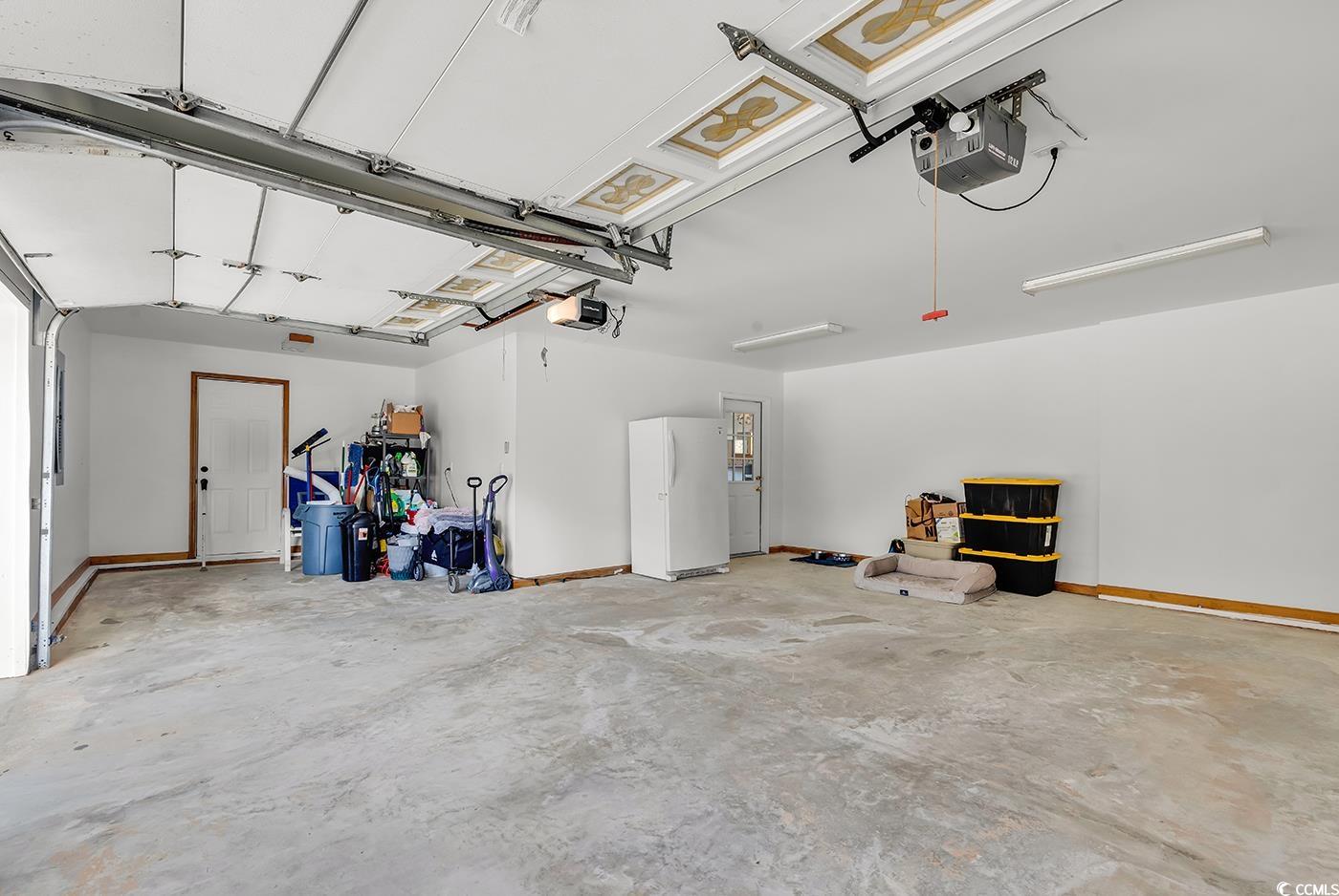 5938 Rahnavard Boulevard Myrtle Beach, SC 29588 - Photo 31 of 39 Garage featuring white fridge and a garage door op