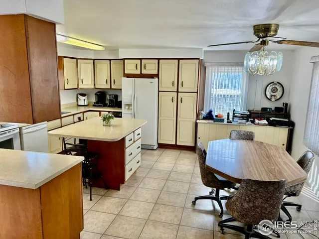 a large kitchen with a table chairs refrigerator and cabinets