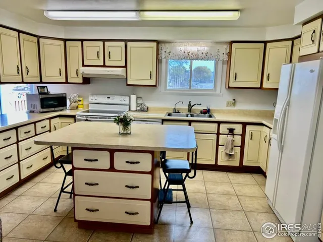 a kitchen with a wooden floor window and chairs