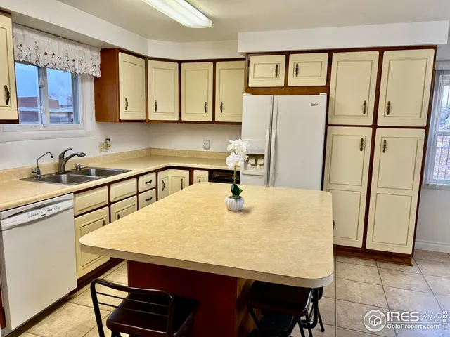 a kitchen with a table chairs refrigerator and cabinets