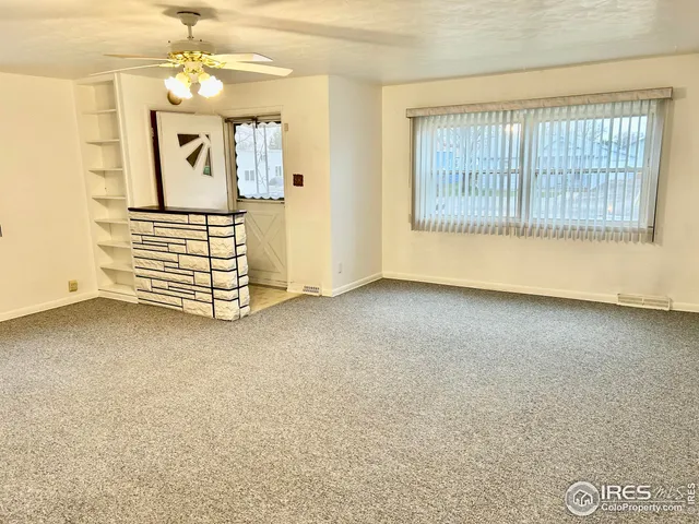 an empty room with windows and cabinet