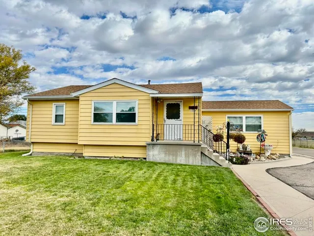a backyard of a house with table and chairs and potted plants