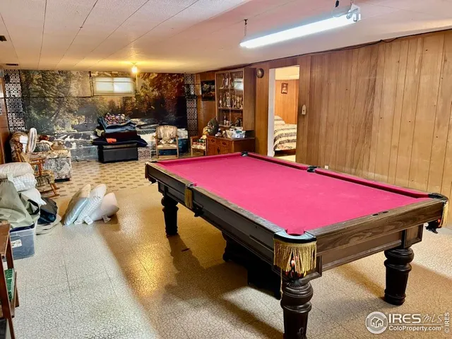 a room with pool table and windows