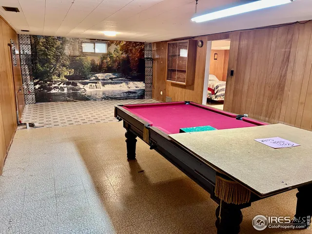 a room with pool table and windows
