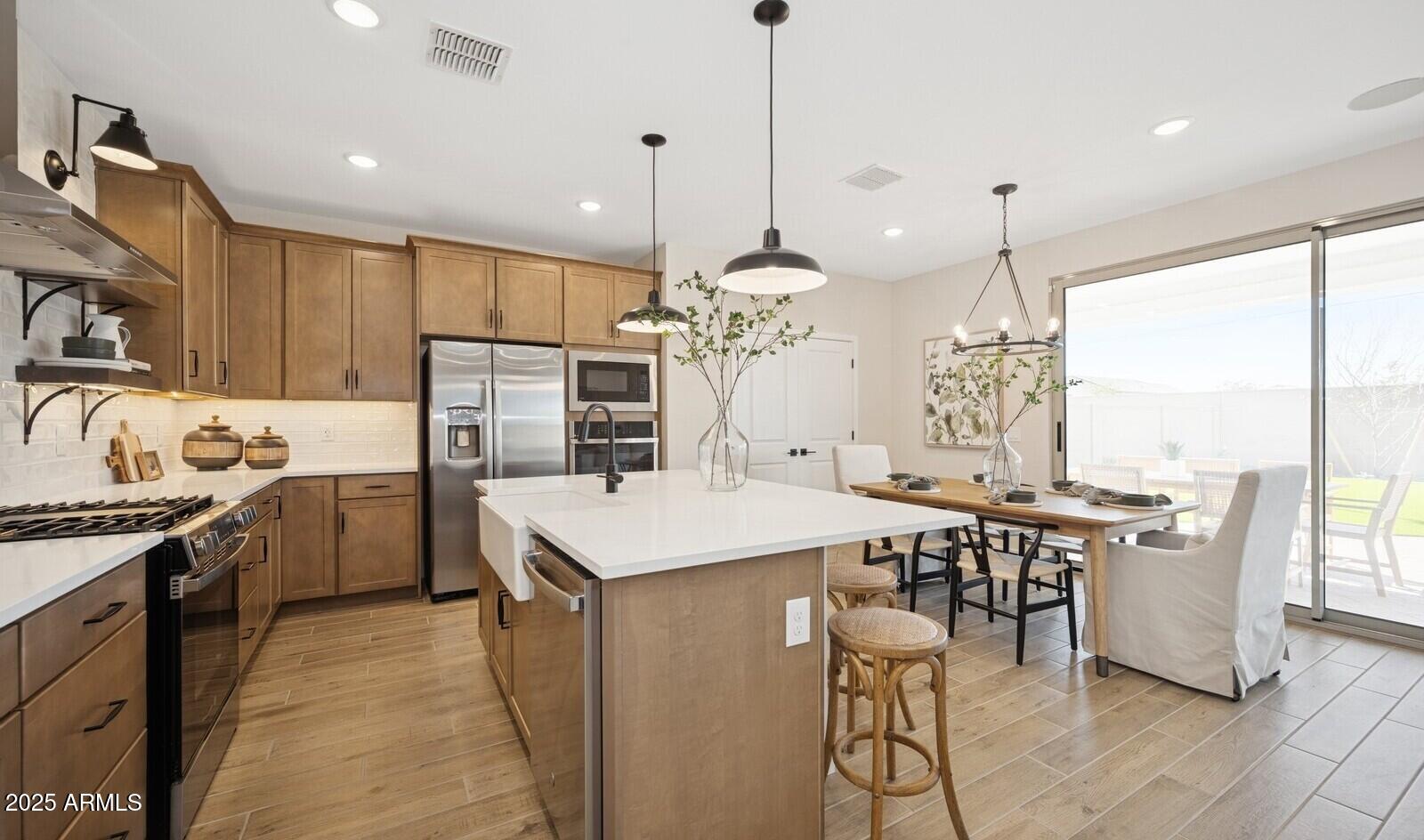 8014 West Royal Palm Road Peoria, AZ 85345 - Photo 7 of 37 a kitchen with kitchen island a large counter top space appliances and a chandelier