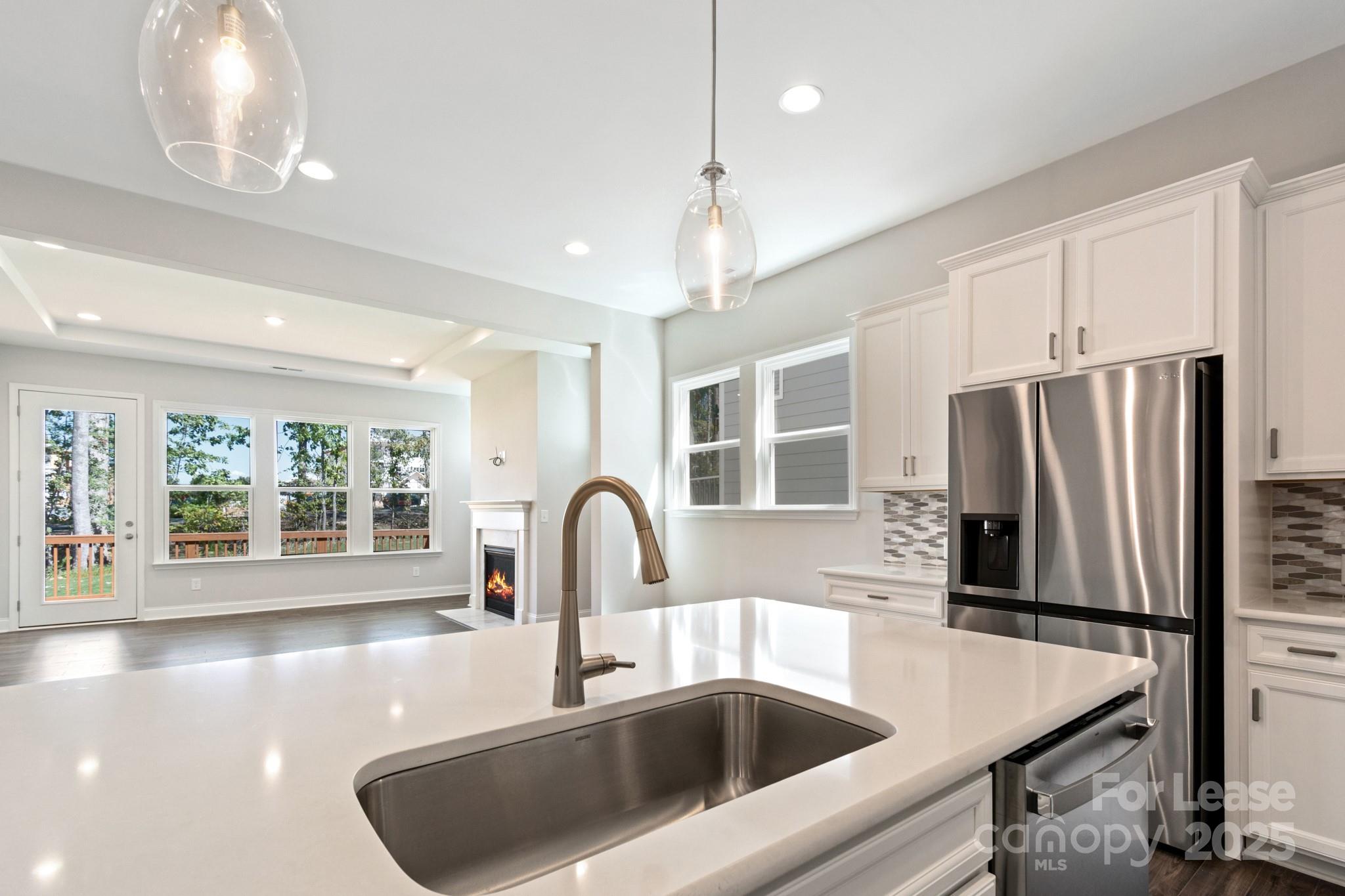 17118 Sand Bank Road Charlotte, NC 28278 - Photo 11 of 37 a kitchen with a refrigerator a sink and a stove with wooden floor