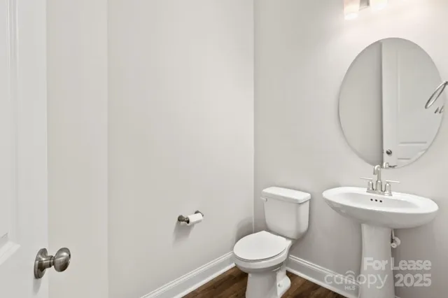 a bathroom with a sink toilet and a mirror