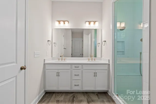 a bathroom with a granite countertop sink a mirror and a shower