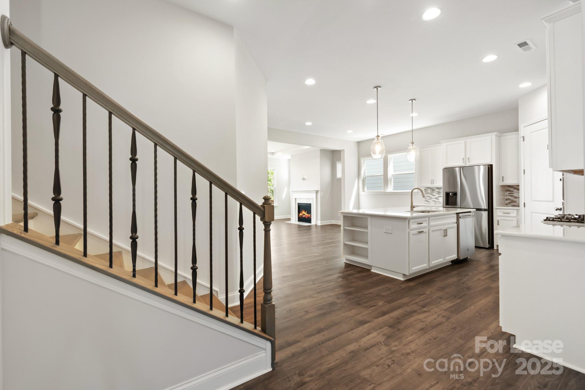 17118 Sand Bank Road Charlotte, NC 28278 - Photo 6 of 37 a large kitchen with stainless steel appliances kitchen island wooden floors and white cabinets