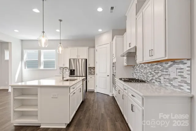 a kitchen with stainless steel appliances kitchen island granite countertop a stove and a sink