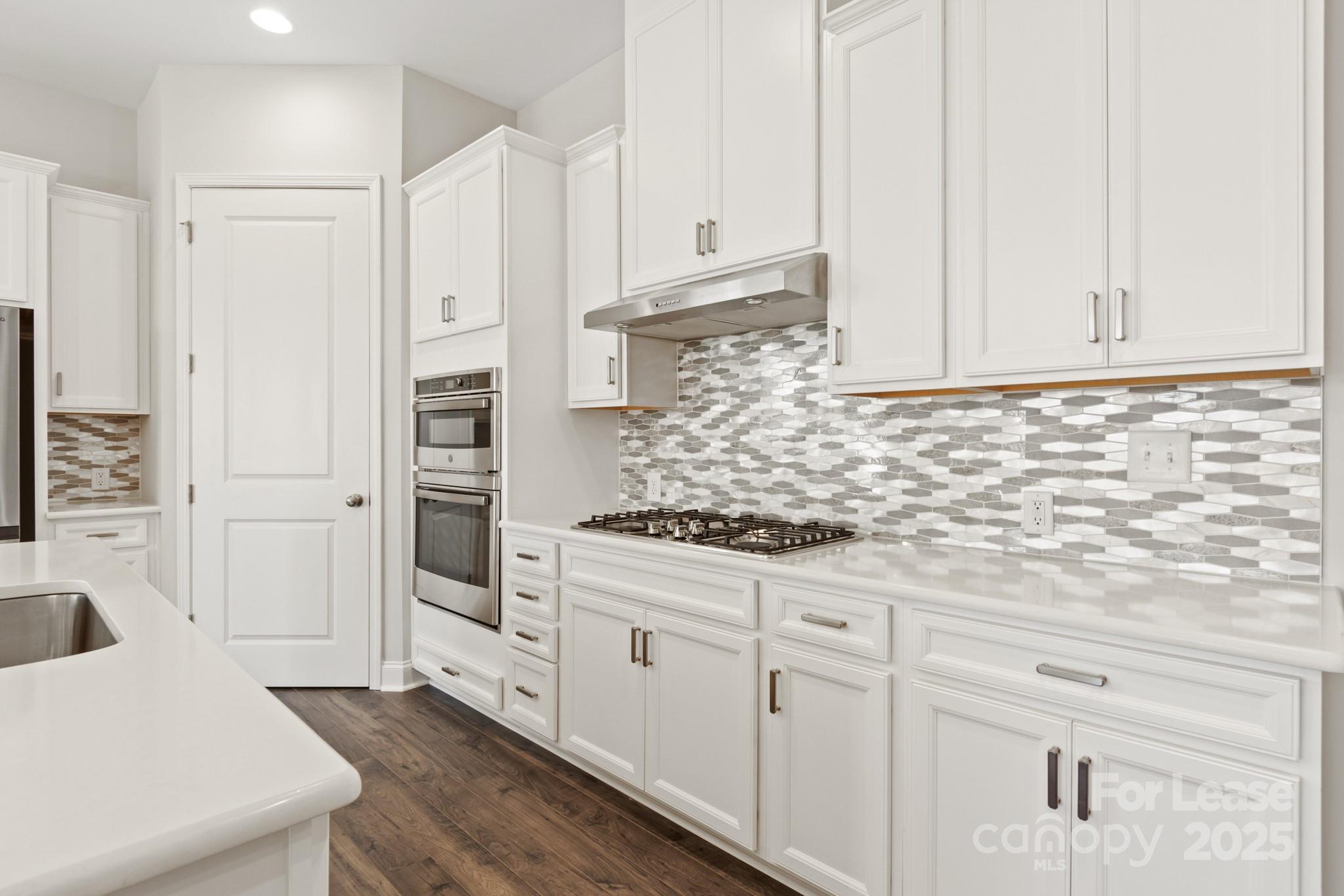 17118 Sand Bank Road Charlotte, NC 28278 - Photo 8 of 37 a kitchen with white cabinets and white appliances