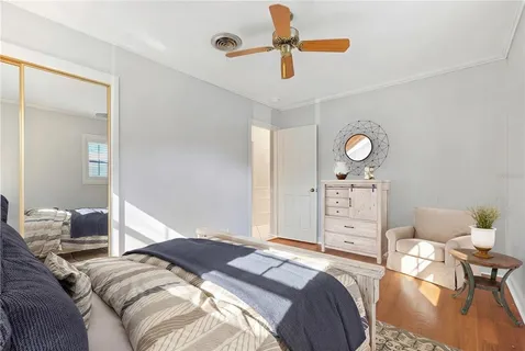 a bedroom with a bed and wooden floor