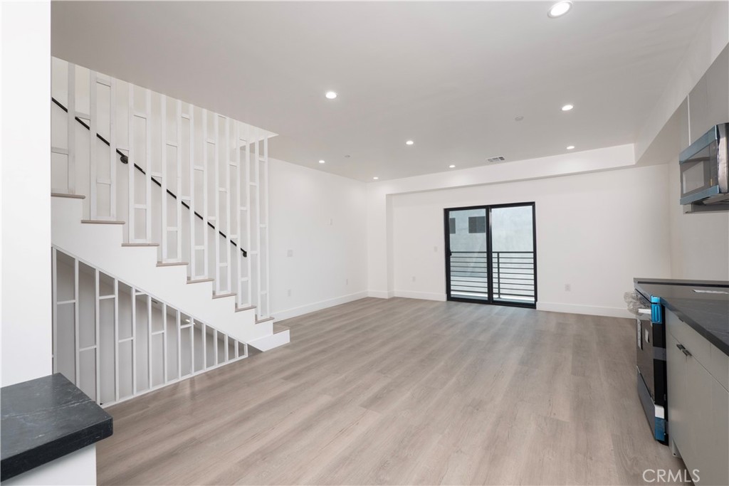 1571 Ricardo Street, Unit 2 Los Angeles, CA 90033 - Photo 25 of 29 a view of an empty room with wooden floor and stairs
