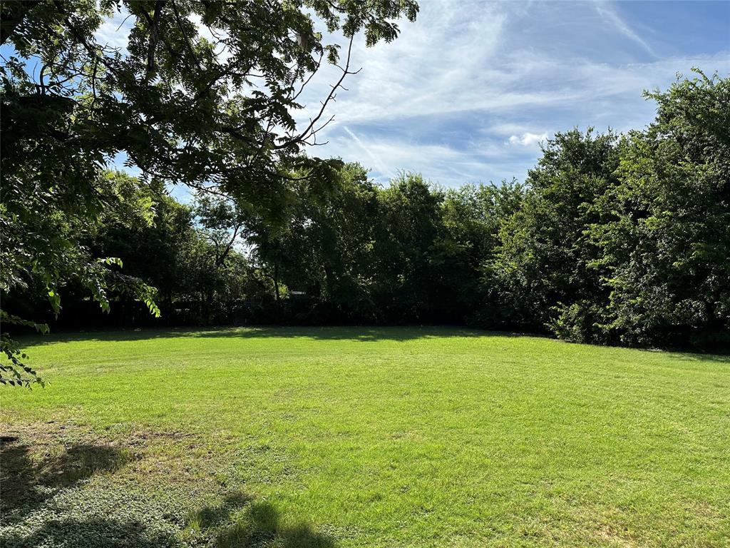 9208 Newhall Street Dallas, TX 75232 - Photo 3 of 8 a view of a field with an trees