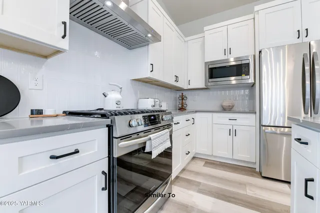a kitchen with white cabinets and white appliances