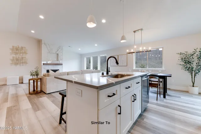 a kitchen with granite countertop a sink appliances and cabinets