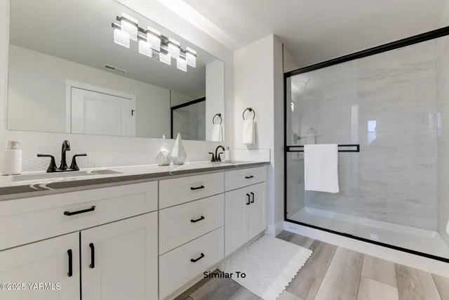 a spacious bathroom with double sink and a mirror
