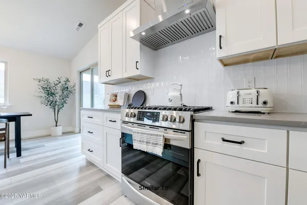 a kitchen with white cabinets and appliances