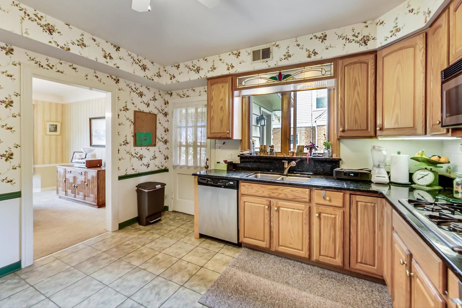 701 South Seminary Avenue Park Ridge, IL 60068 - Photo 16 of 60 a large white kitchen with granite countertop a stove a sink a window and stainless steel appliances