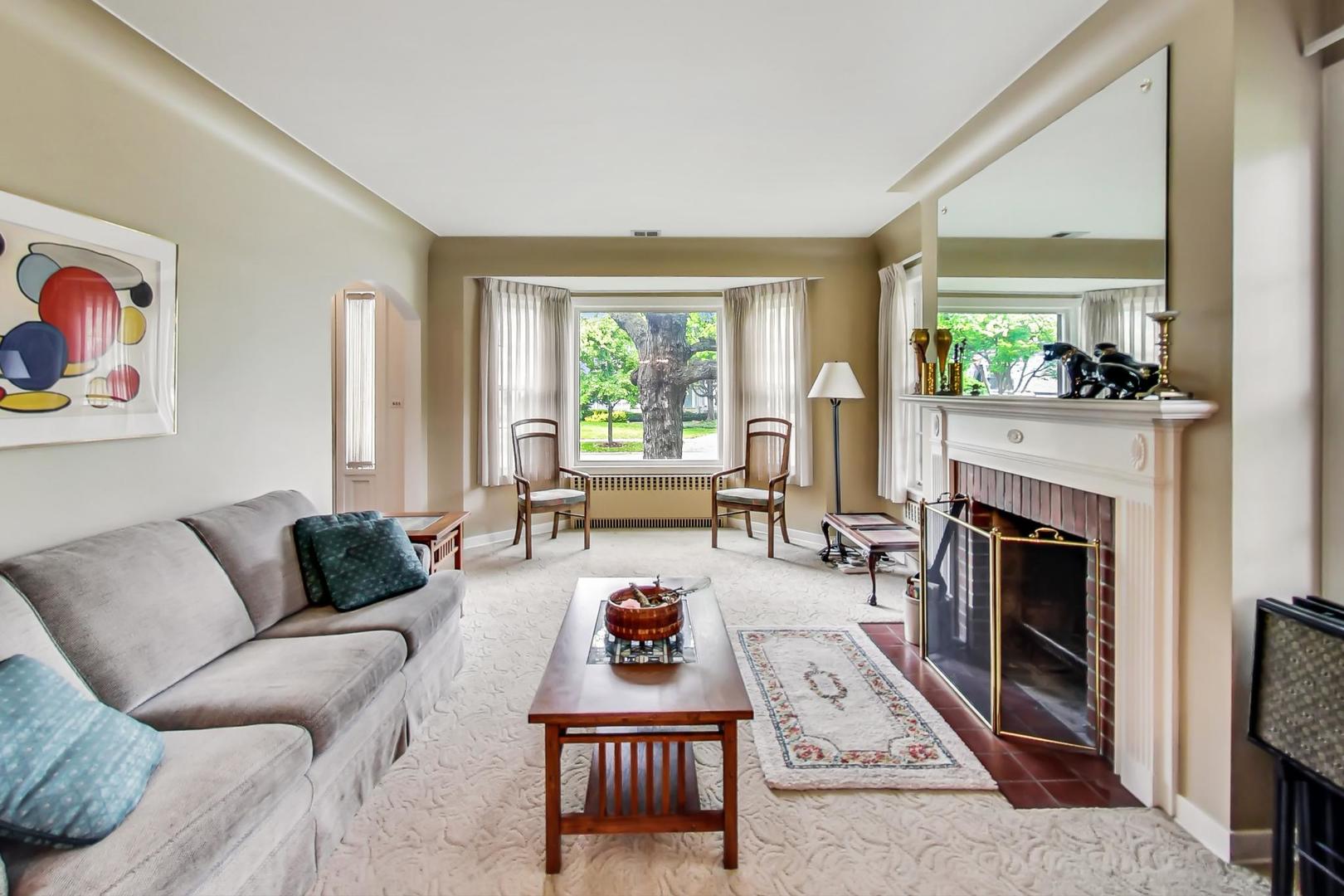 701 South Seminary Avenue Park Ridge, IL 60068 - Photo 10 of 60 a living room with furniture a fireplace and a large window