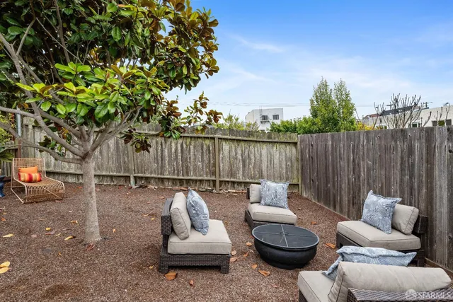 a view of a patio with couches table and chairs and potted plants