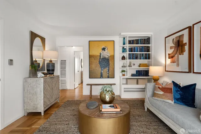 a picture of a living room with furniture and a book shelf