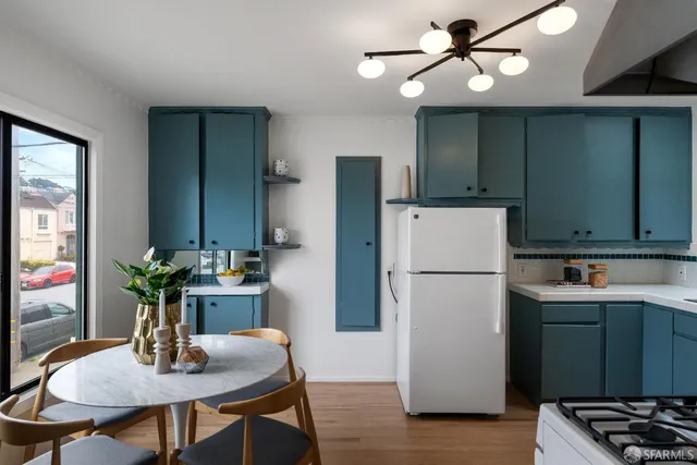 a kitchen with stainless steel appliances a stove a sink cabinets and a refrigerator
