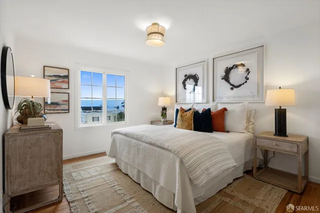 a bedroom with a bed and a painting on the wall