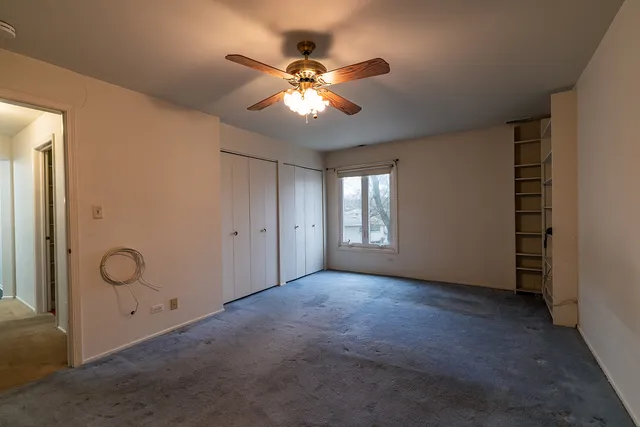 a view of a livingroom with a ceiling fan and window