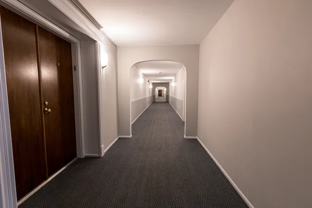 a view of a hallway with wooden floor