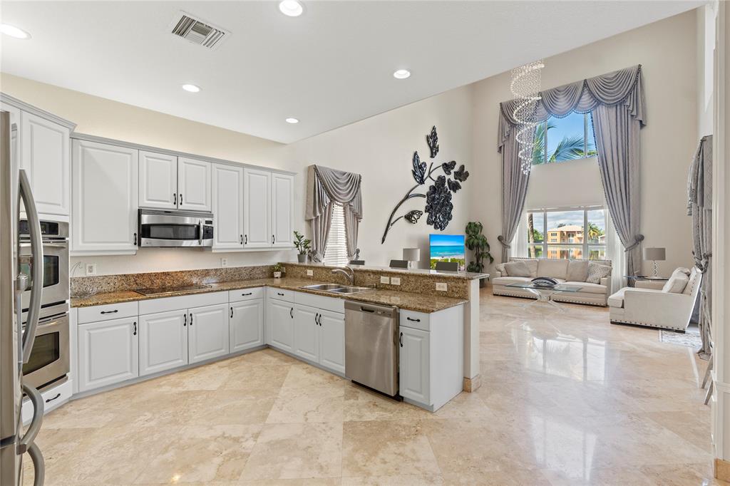 4622 Southwest 185th Avenue Miramar, FL 33029 - Photo 14 of 64 a large kitchen with kitchen island granite countertop a sink and white cabinets