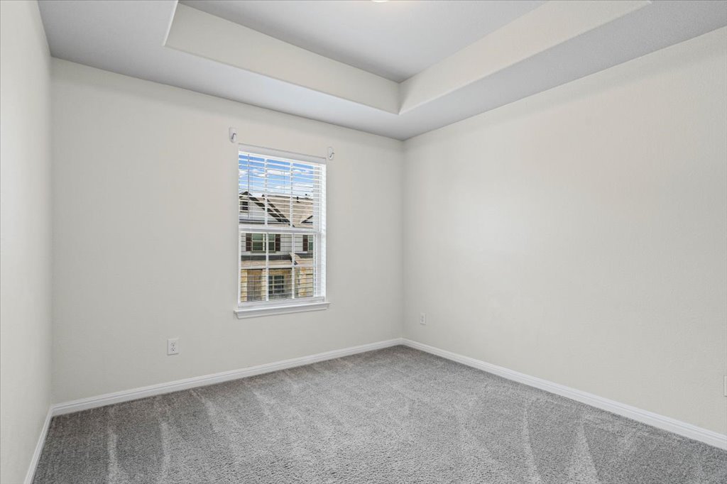 1502 Airedale Road, Unit 2502 Austin, TX 78748 - Photo 21 of 28 A well-lit bedroom features plush carpeting and a high tray ceiling.