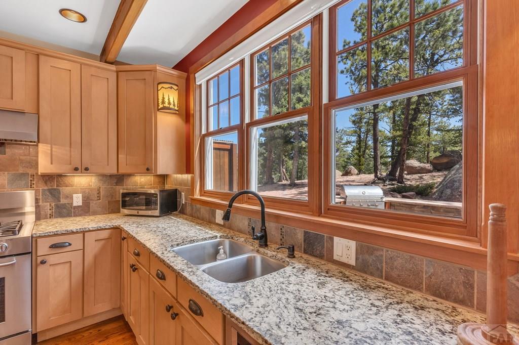 10 Robert Road Rye, CO 81069 - Photo 21 of 102 a kitchen with stainless steel appliances granite countertop a sink a stove and a wooden floors