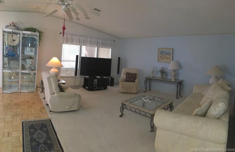 16152 Southwest Five Wood Way Indiantown, FL 34956 - Photo 3 of 9 a living room with furniture a chandelier and a flat screen tv