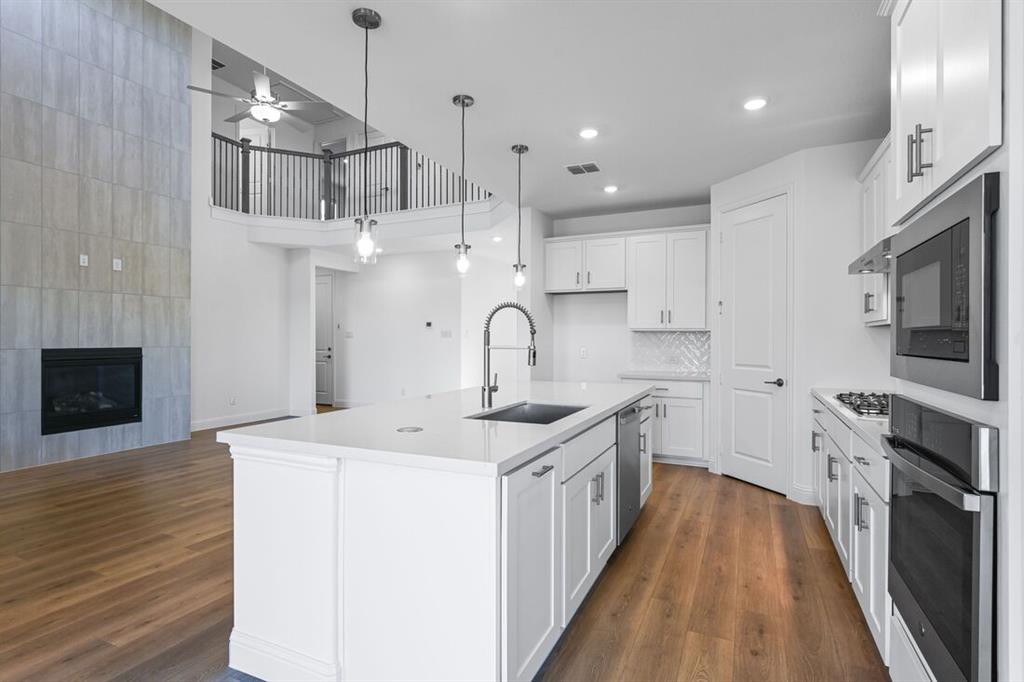 614 Bull Street Oak Point, TX 75068 - Photo 5 of 36 a kitchen with stainless steel appliances granite countertop a sink stove and refrigerator