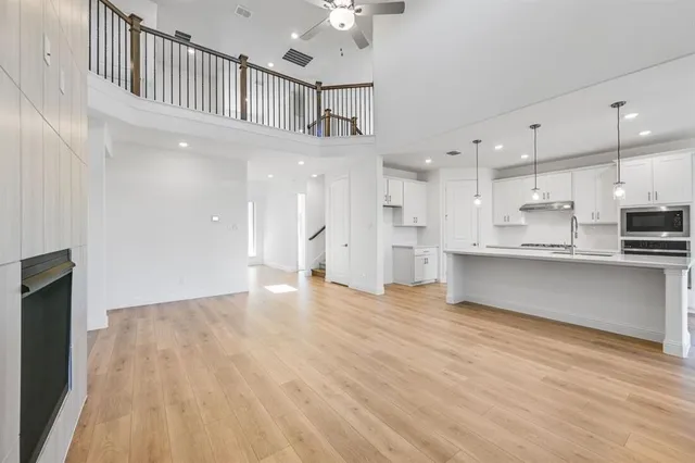 a view of kitchen with kitchen island wooden floor center island and stainless steel appliances