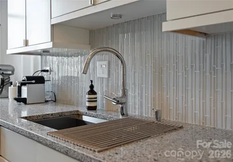 a kitchen with stainless steel appliances granite countertop a stove a sink and a white cabinets