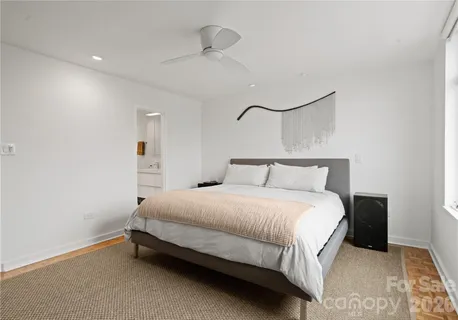 a bedroom with a bed and a painting on the wall