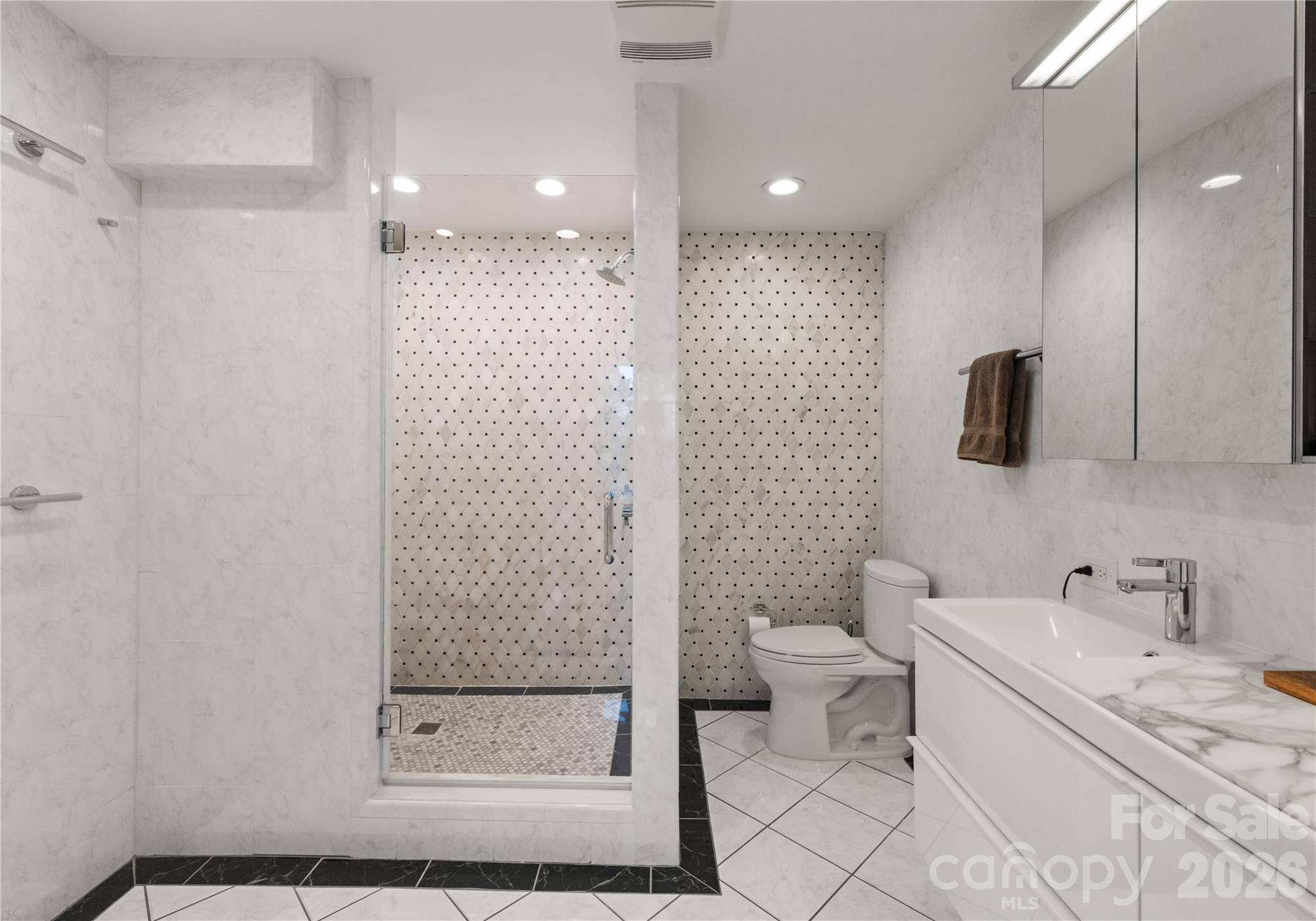 1300 Queens Road Charlotte, NC 28207 - Photo 26 of 45 a bathroom with a double vanity sink toilet and shower