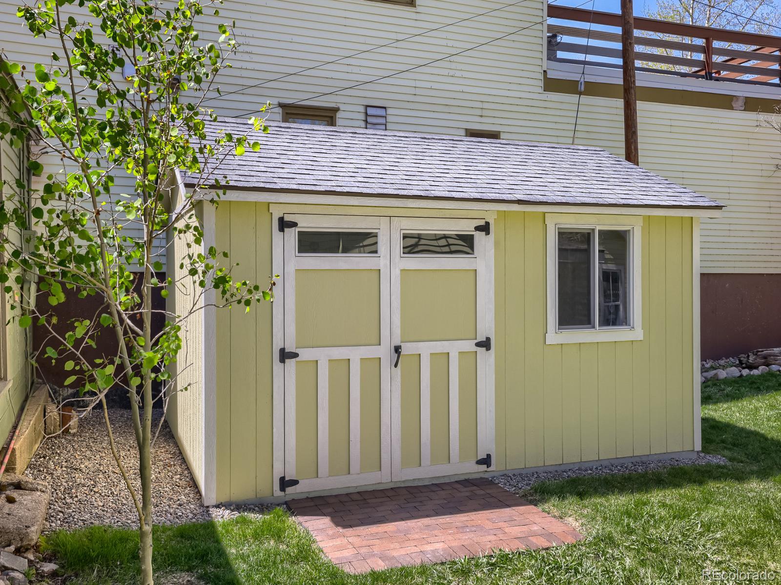 407 Seventh Street Georgetown, CO 80444 - Photo 23 of 28 a view of a brick house with plants and wooden fence