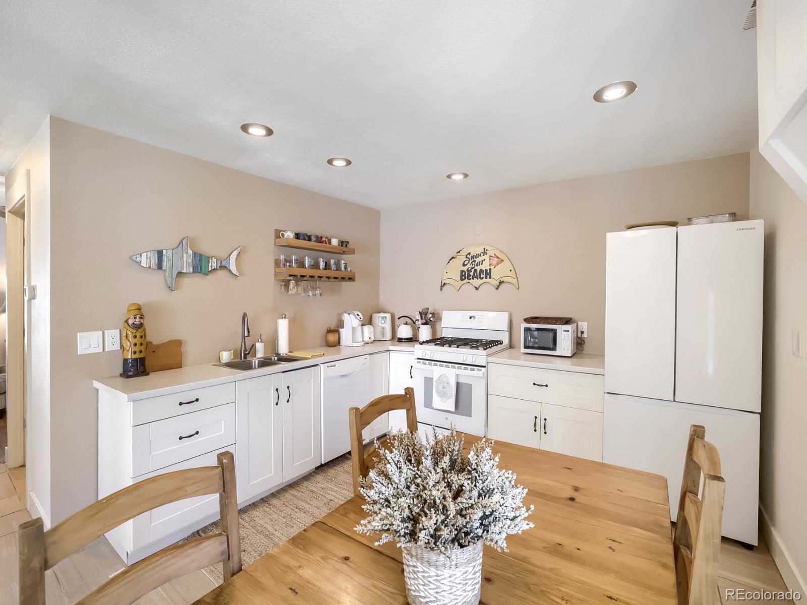 407 Seventh Street Georgetown, CO 80444 - Photo 8 of 28 a kitchen with granite countertop a refrigerator a stove a sink dishwasher and white cabinets with wooden floor